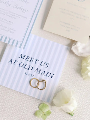 Wedding invitation with gold rings and flowers on a textured surface
