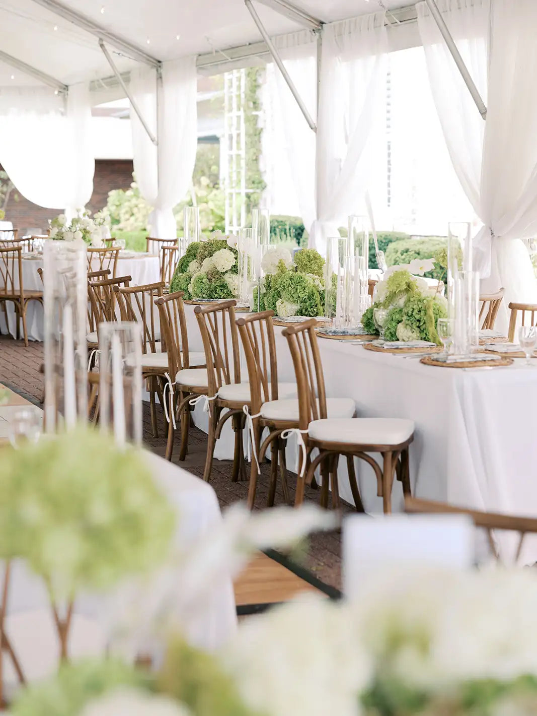 Elegant outdoor wedding reception with tables, chairs, and floral decorations.