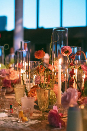 Decorative table setting with flowers and candles in a blurred indoor setting