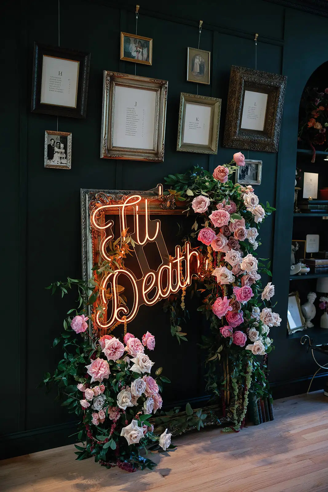 Neon sign with floral decorations against a dark wall